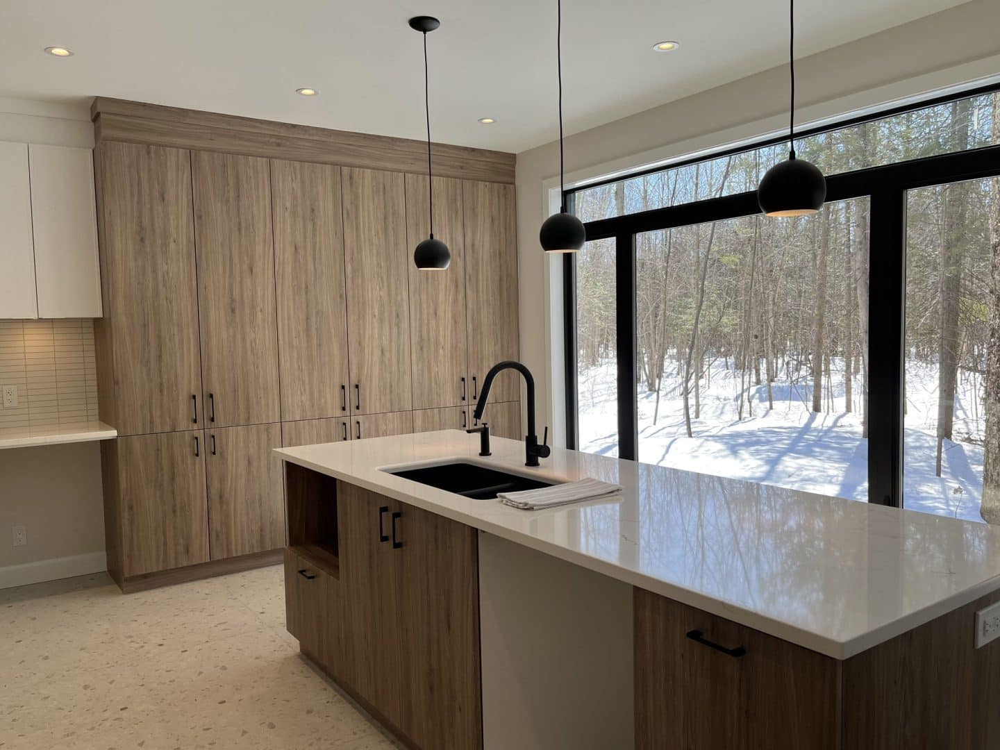 Une réalisation d'une maison ProFab d'un prestigieux plain-pied de style farmhouse contemporain construit sur mesure. Vu de la cuisine.