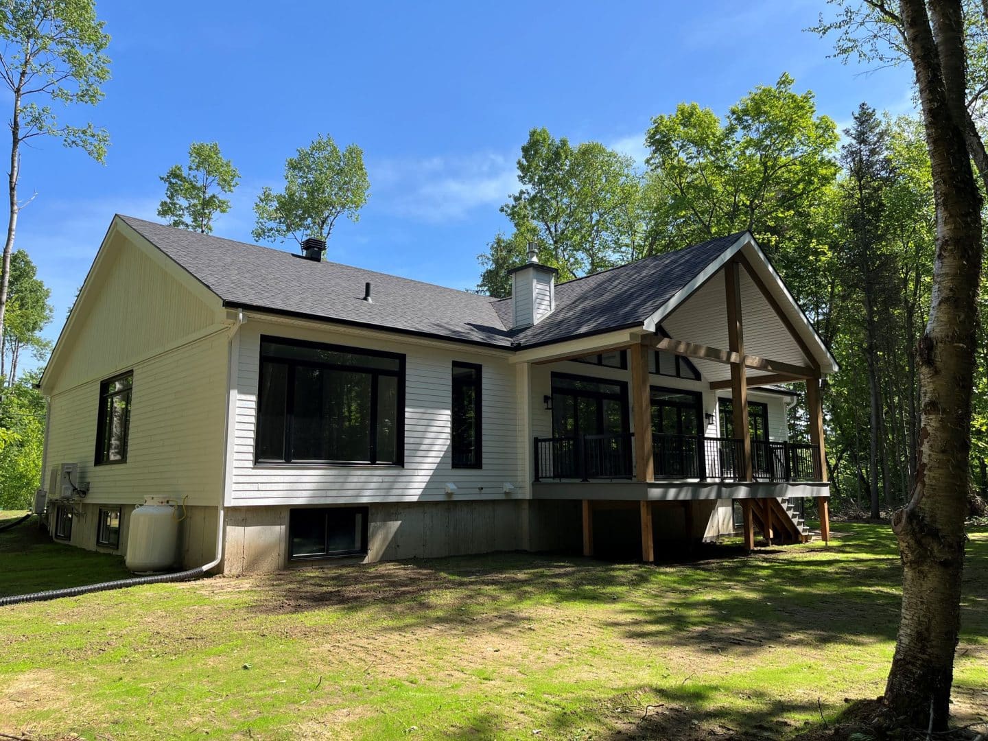 Une réalisation d'une maison ProFab d'un prestigieux plain-pied de style farmhouse contemporain construit sur mesure. Vu d'extérieur.