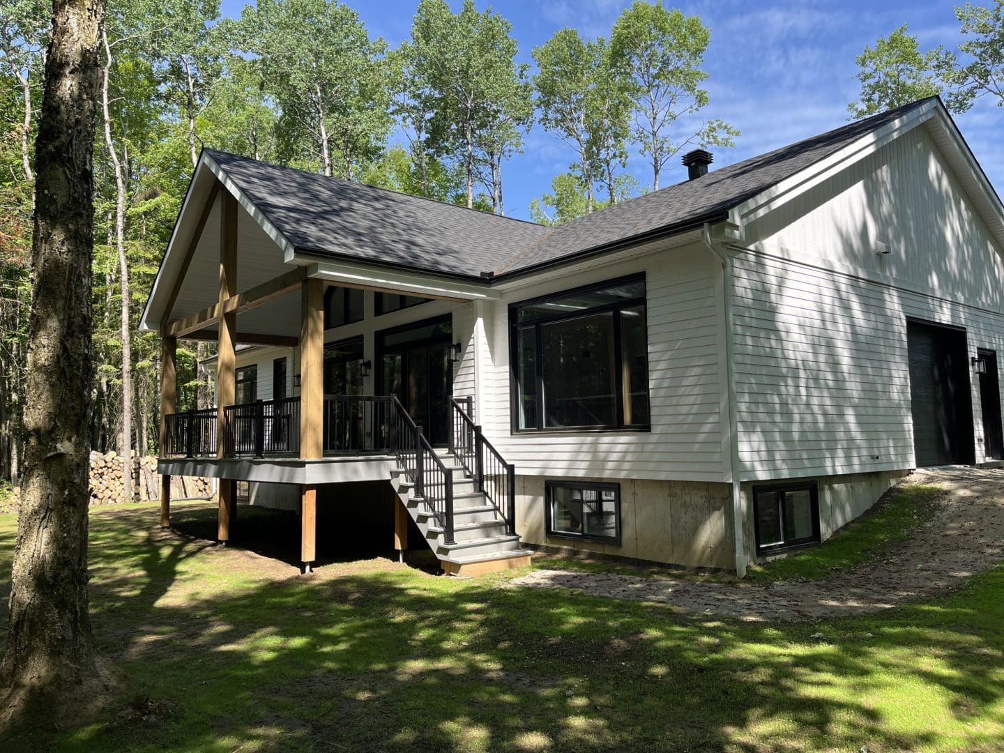 Une réalisation d'une maison ProFab d'un prestigieux plain-pied de style farmhouse contemporain construit sur mesure. Vu d'extérieur.