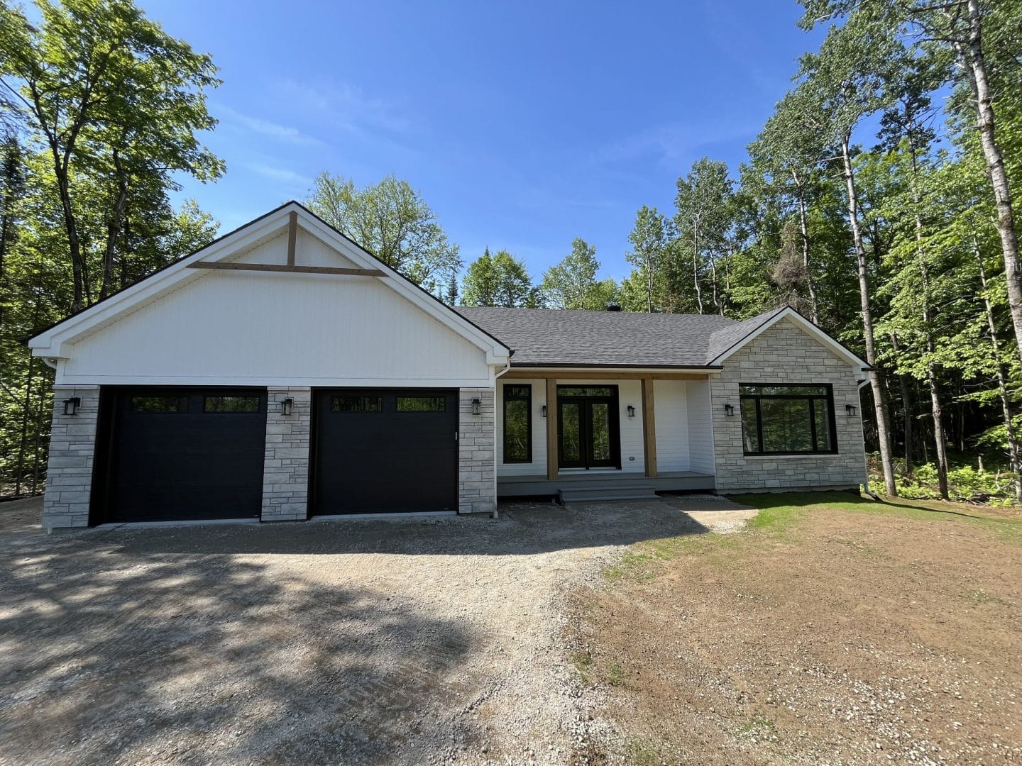 Une réalisation d'une maison ProFab d'un prestigieux plain-pied de style farmhouse contemporain construit sur mesure. Vu d'extérieur.