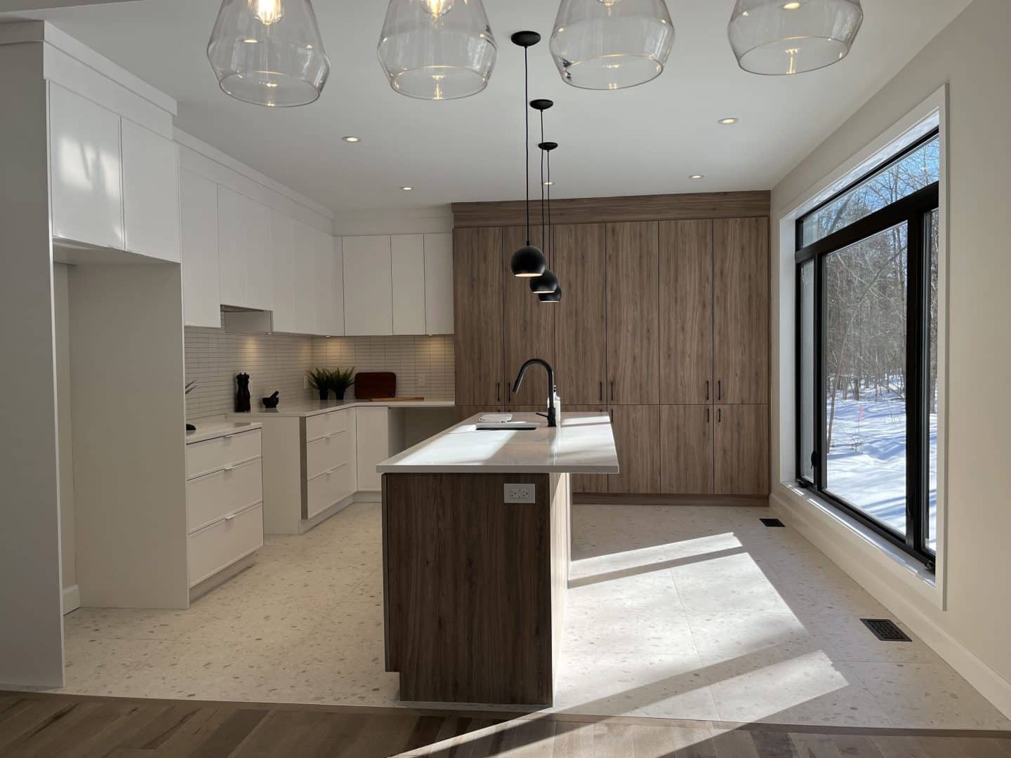 Une réalisation d'une maison ProFab d'un prestigieux plain-pied de style farmhouse contemporain construit sur mesure. Vu de la cuisine.