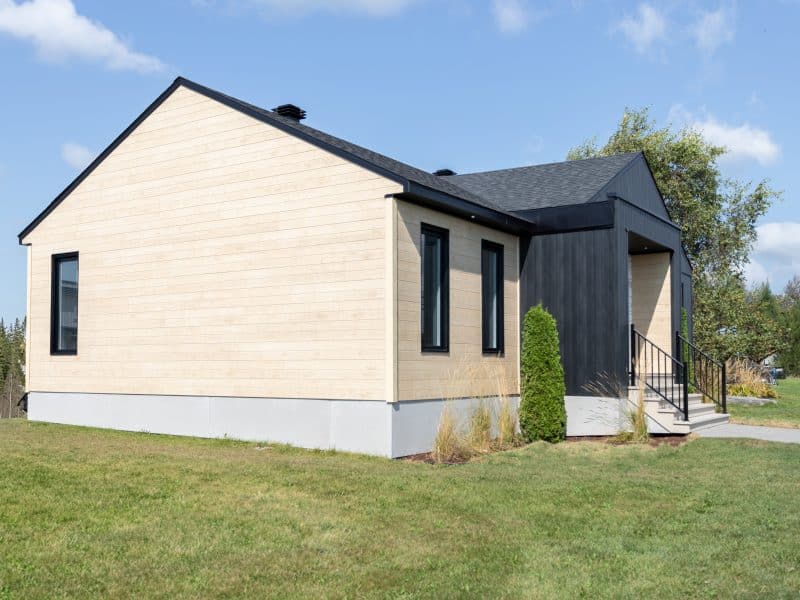 Une maison de plain-pied appelée Emile. Le premier étage est de style contemporain, vu de l'extérieur.