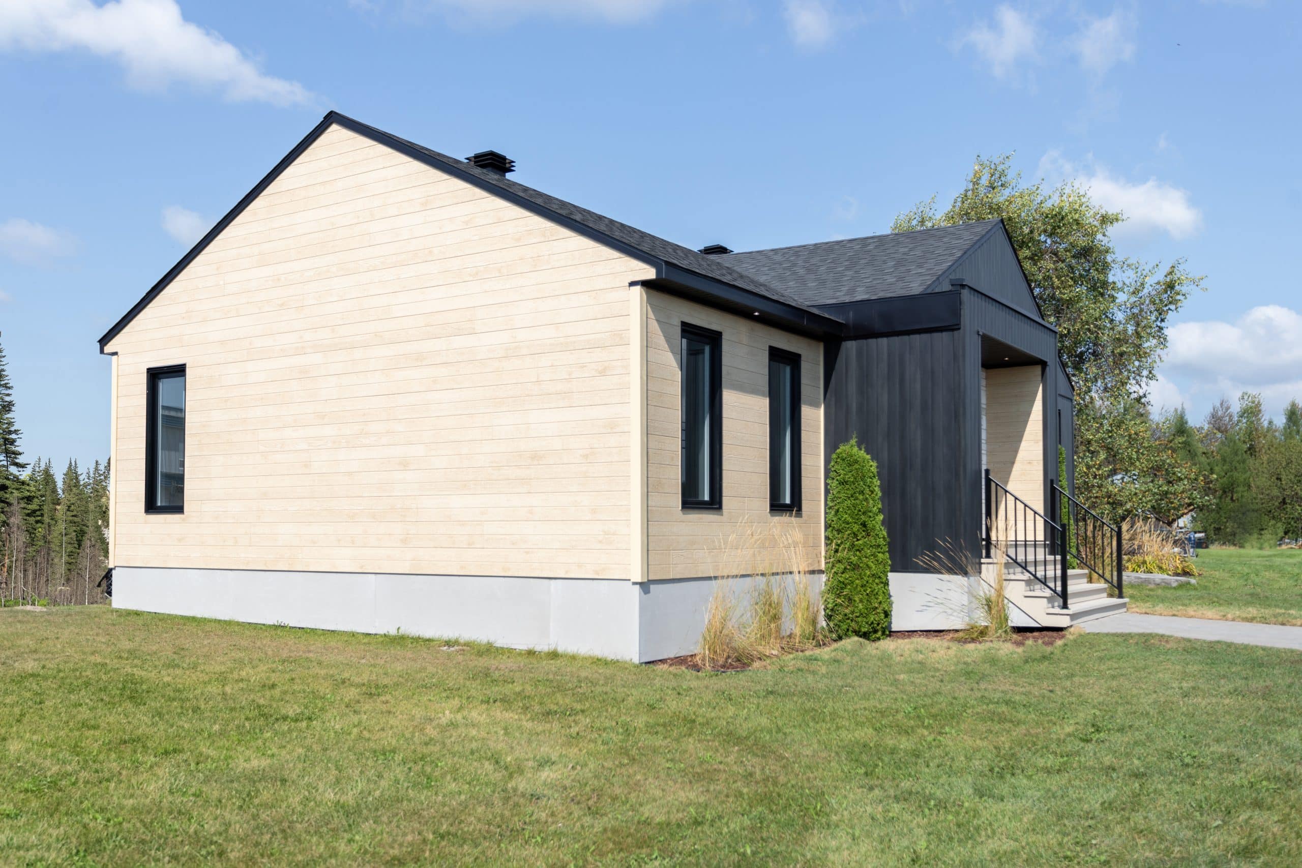 Une maison de plain-pied appelée Emile. Le premier étage est de style contemporain, vu de l'extérieur.