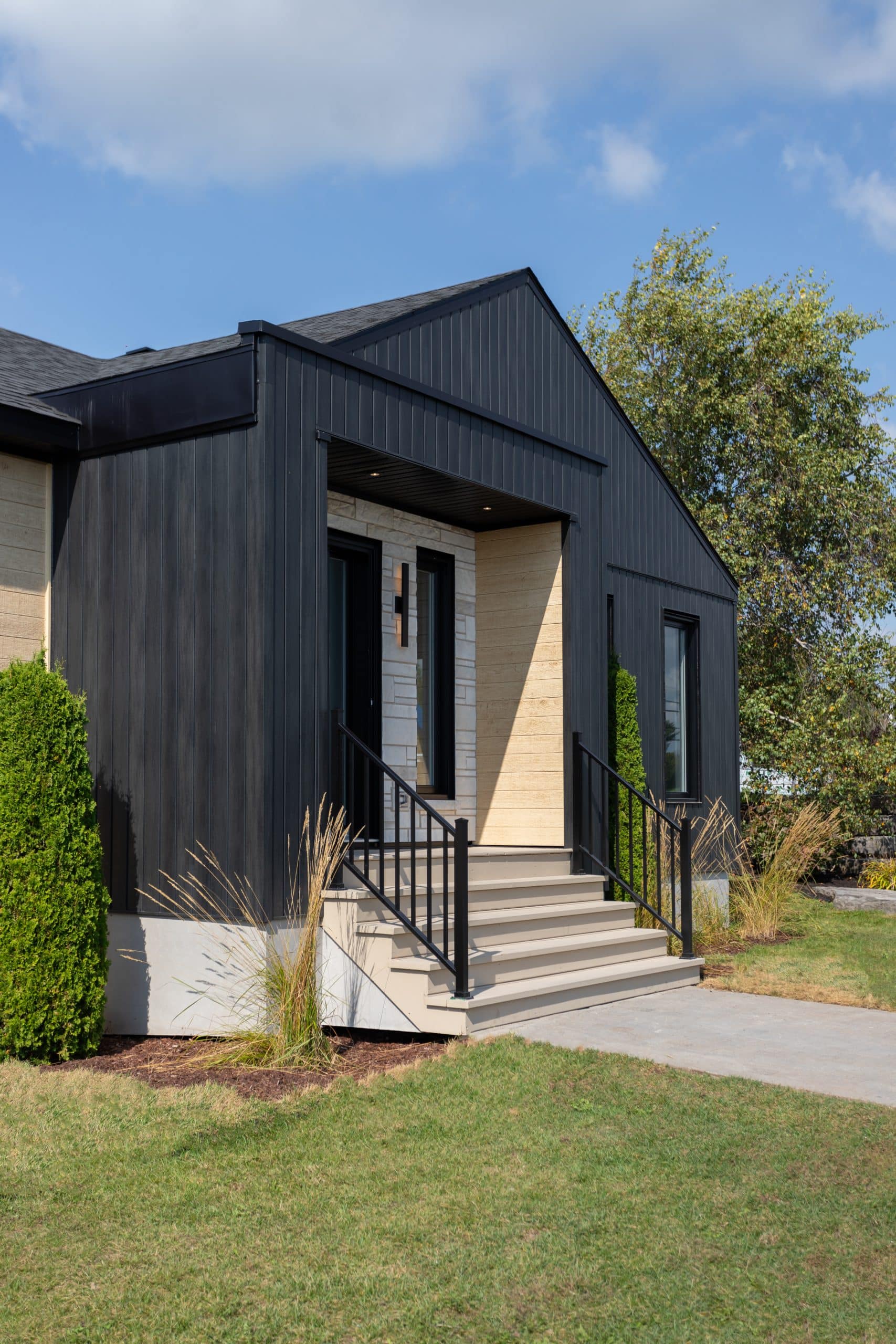 Une maison de plain-pied appelée Emile. Le premier étage est de style contemporain, vu de l'extérieur.
