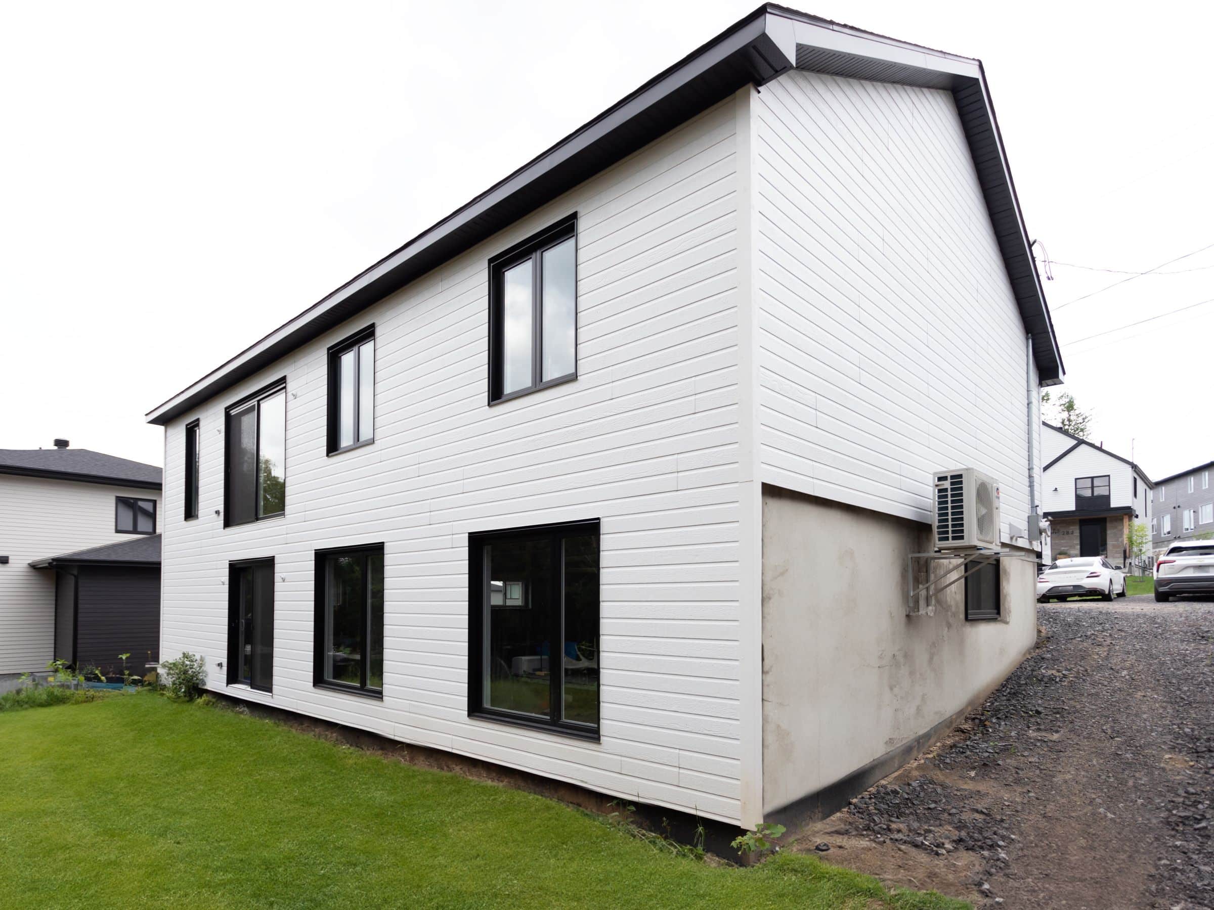 Une réalisation d'une maison appelée Lata. Le premier étage est de style contemporain, vu de l'extérieur.