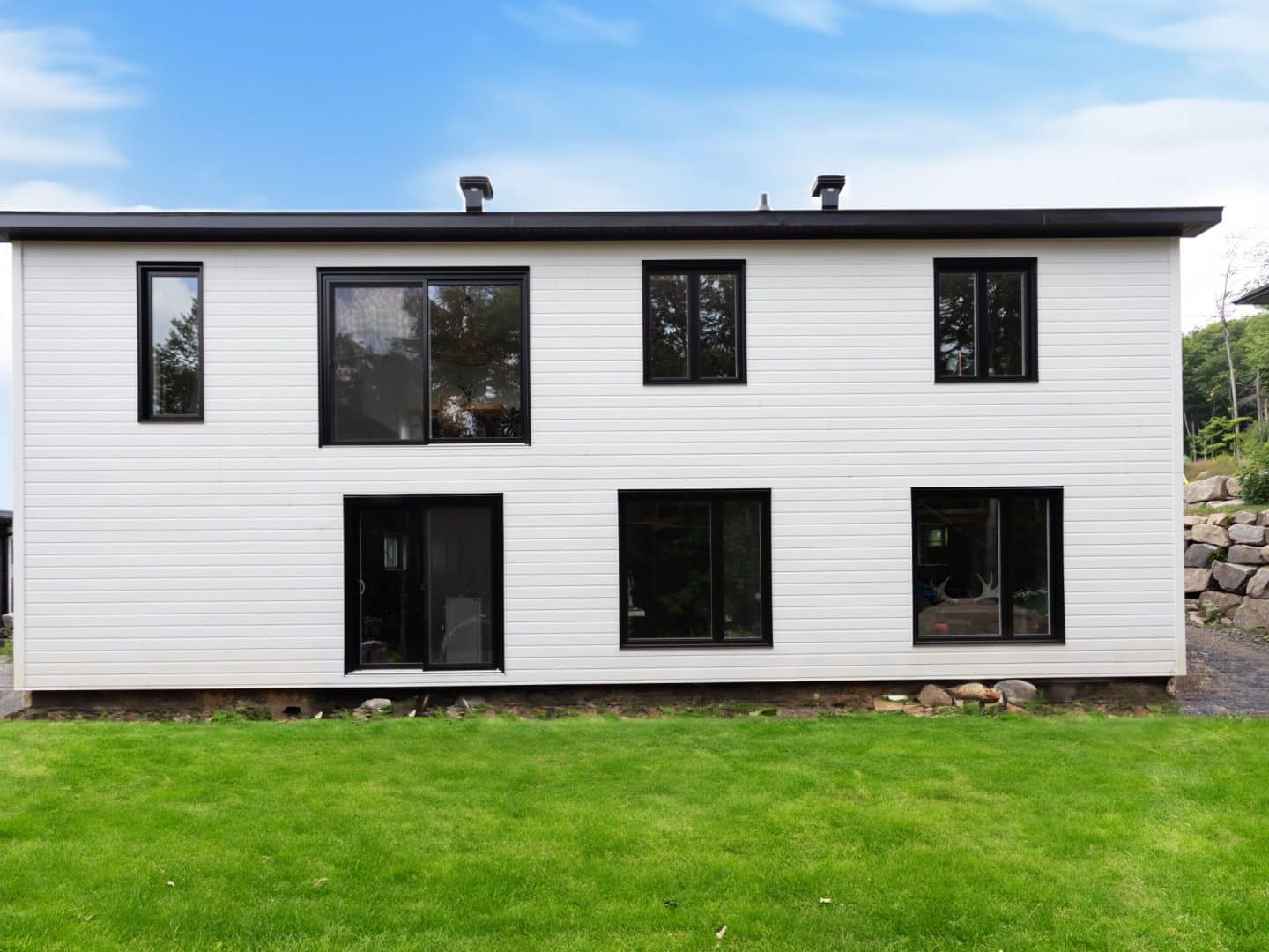 Une réalisation d'une maison appelée Lata. Le premier étage est de style contemporain, vu de l'extérieur.