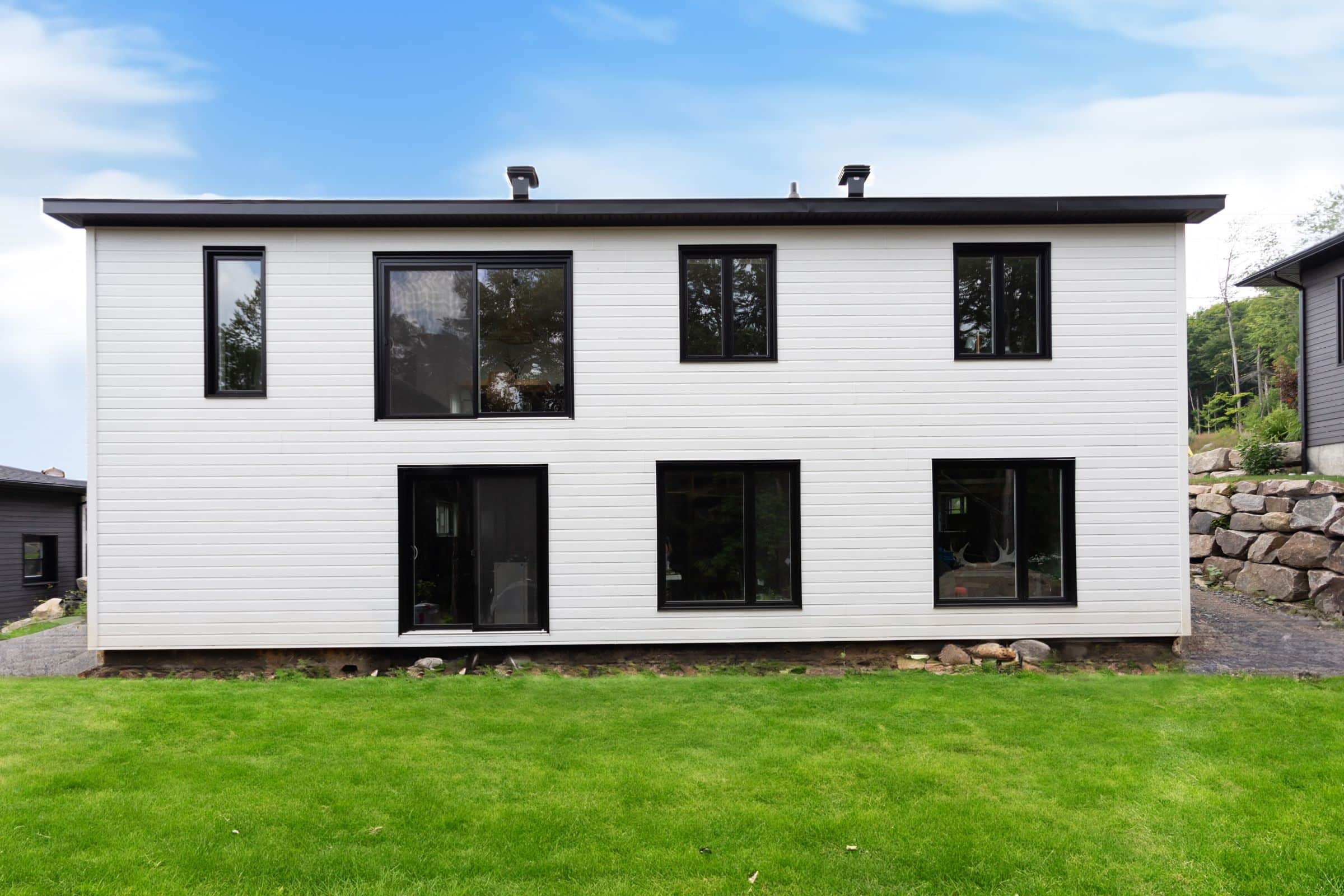 Une réalisation d'une maison appelée Lata. Le premier étage est de style contemporain, vu de l'extérieur.